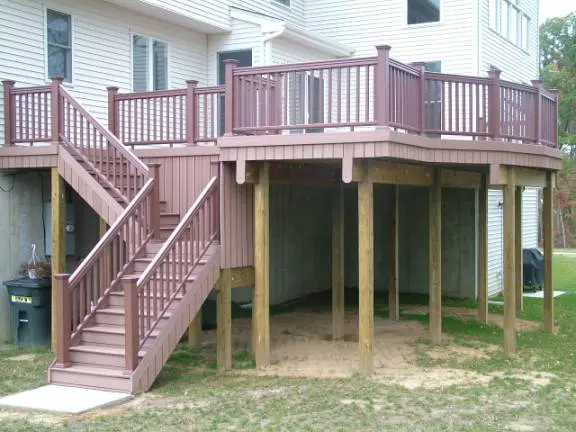 An outdoor deck equipped with stairs and a protective railing, designed for safety and ease of access to the space.