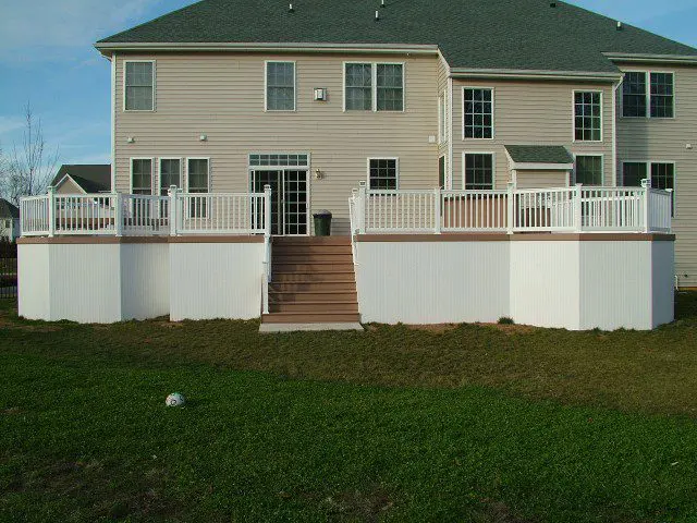 A well-constructed deck with a white railing and steps, enhancing the aesthetic appeal of the outdoor area.